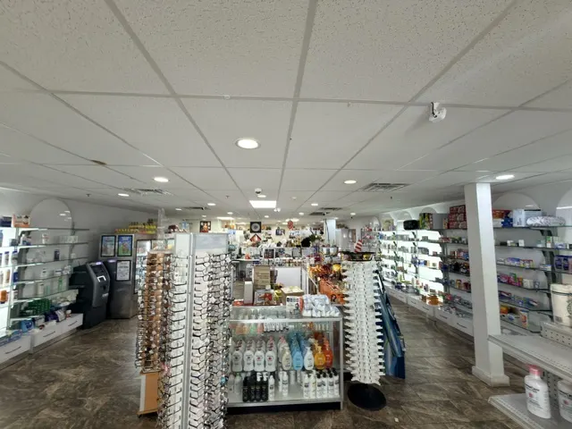 Wide aisle of stocked over-the-counter and health product shelves inside Patient Care Pharmacy